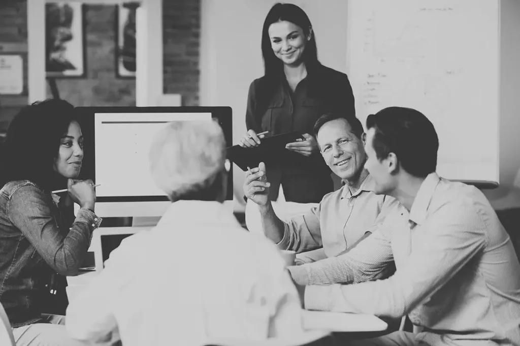 A diverse group of professionals engaged in a collaborative discussion during an office meeting.